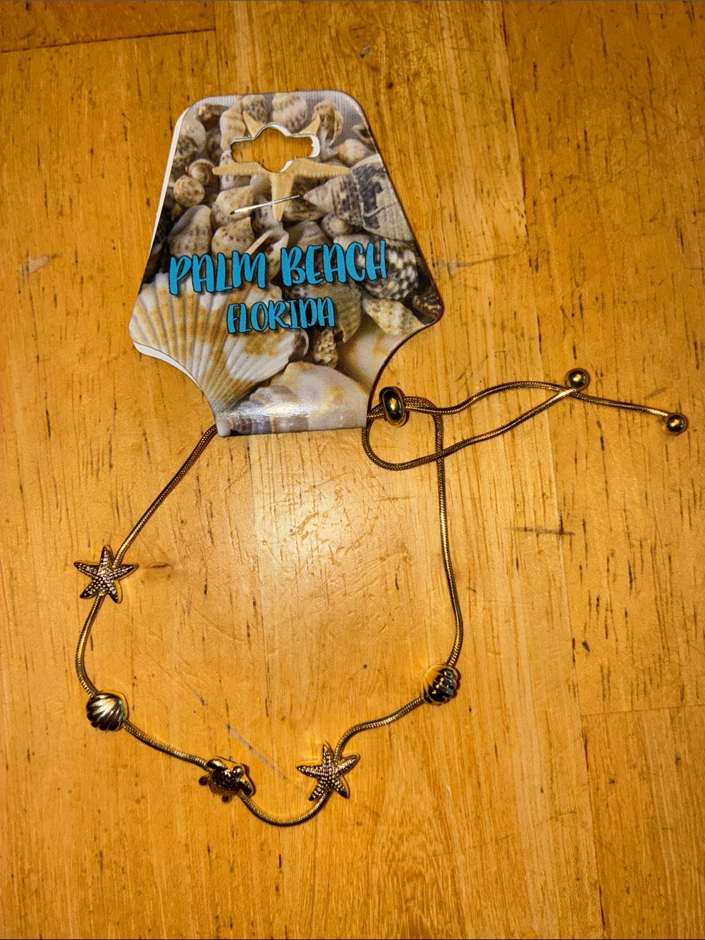 Gold tone beach themed charm adjustable bracelet. NWT.
